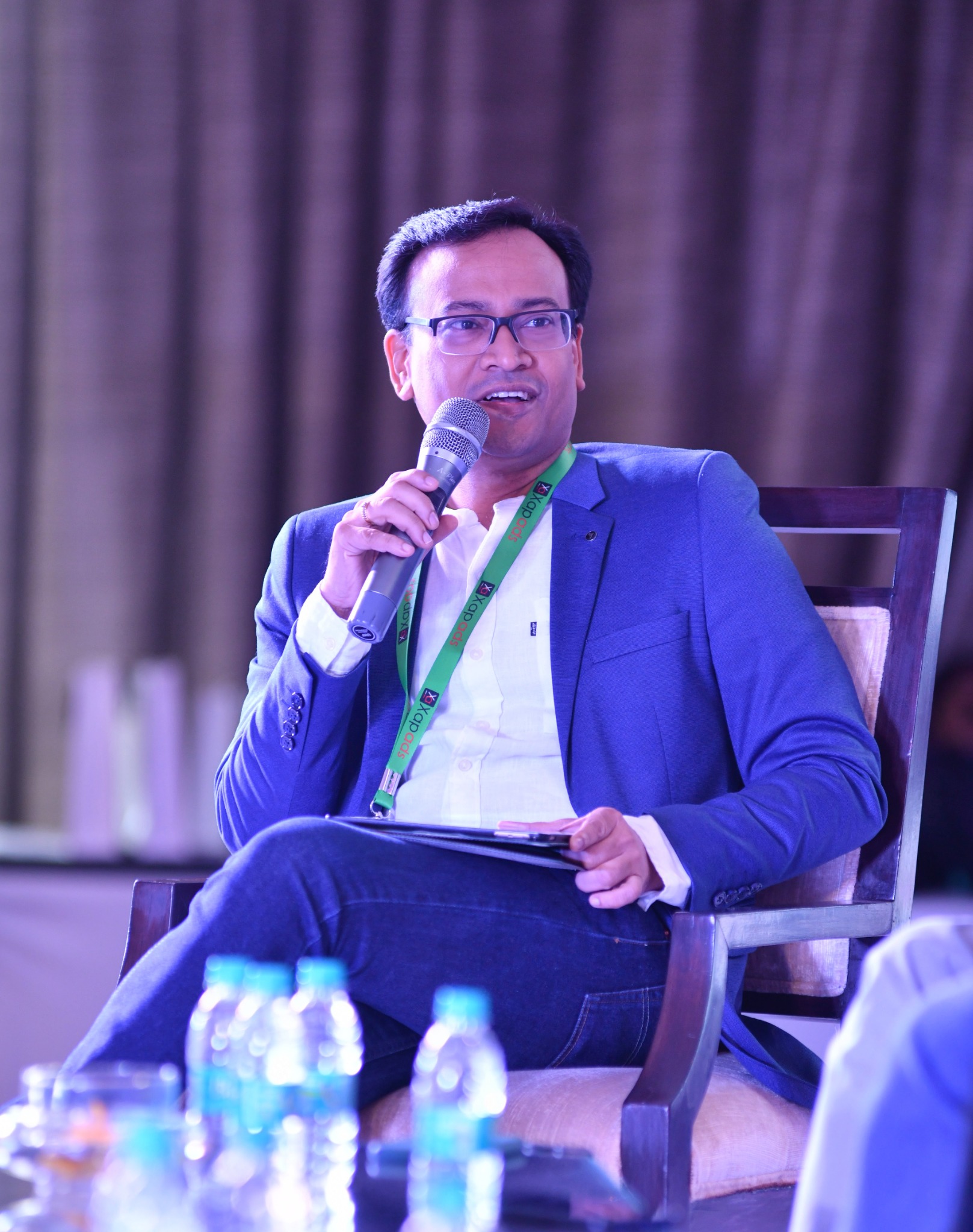 Anil Pandit participating in a seated panel discussion, holding a microphone